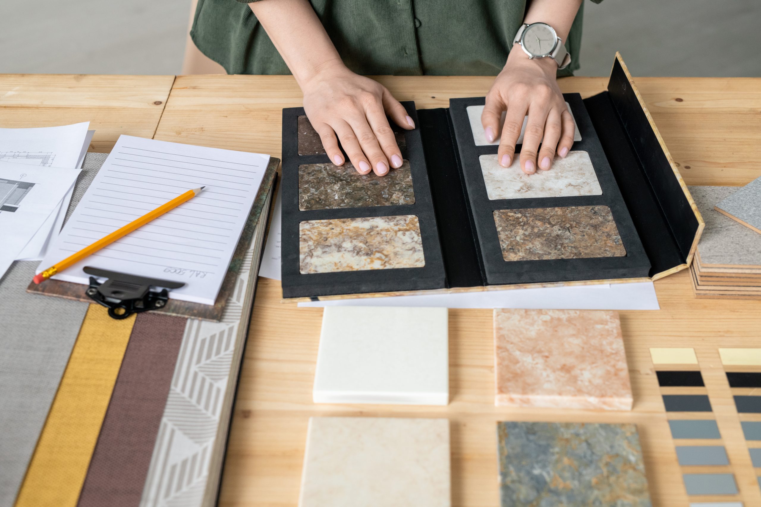 hands designer samples marble tile surrounded by wallpaper patterns work scaled